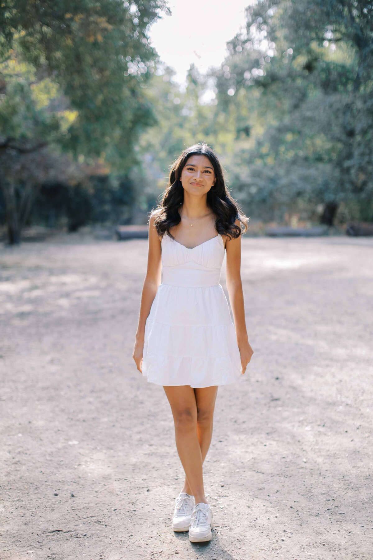 palo alto senior girl wearing a white dress and smiling at the camera