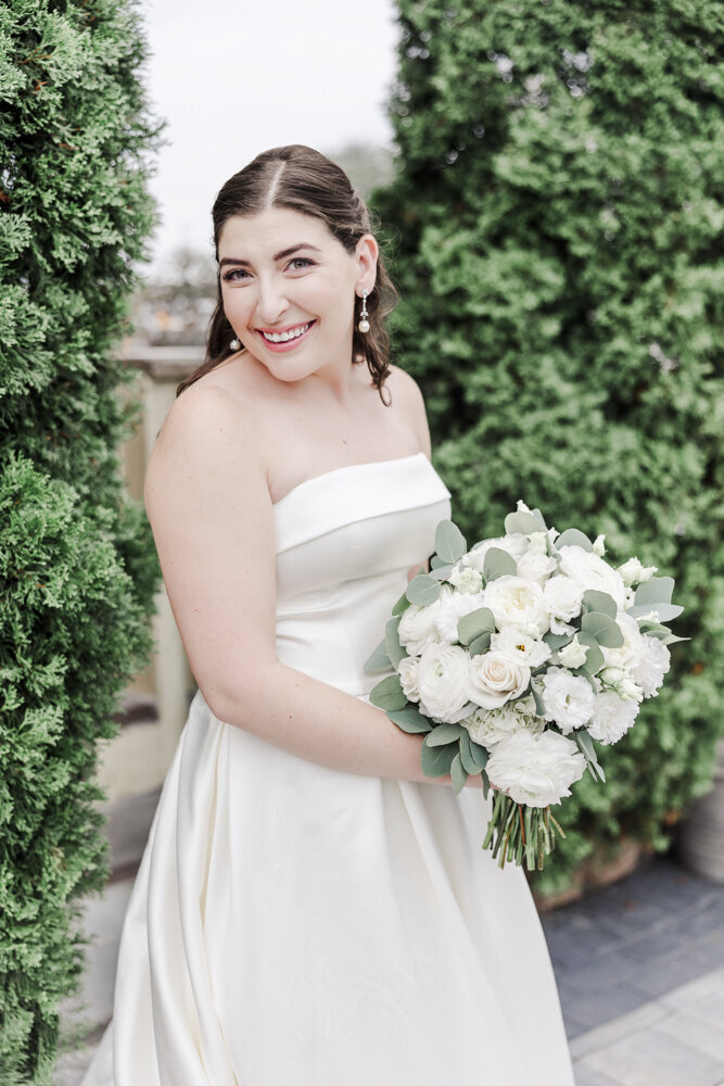 bride smiling while holding flower bouquet