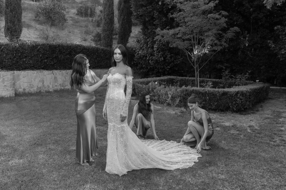 bride getting made up by bridesmaids in courtyard