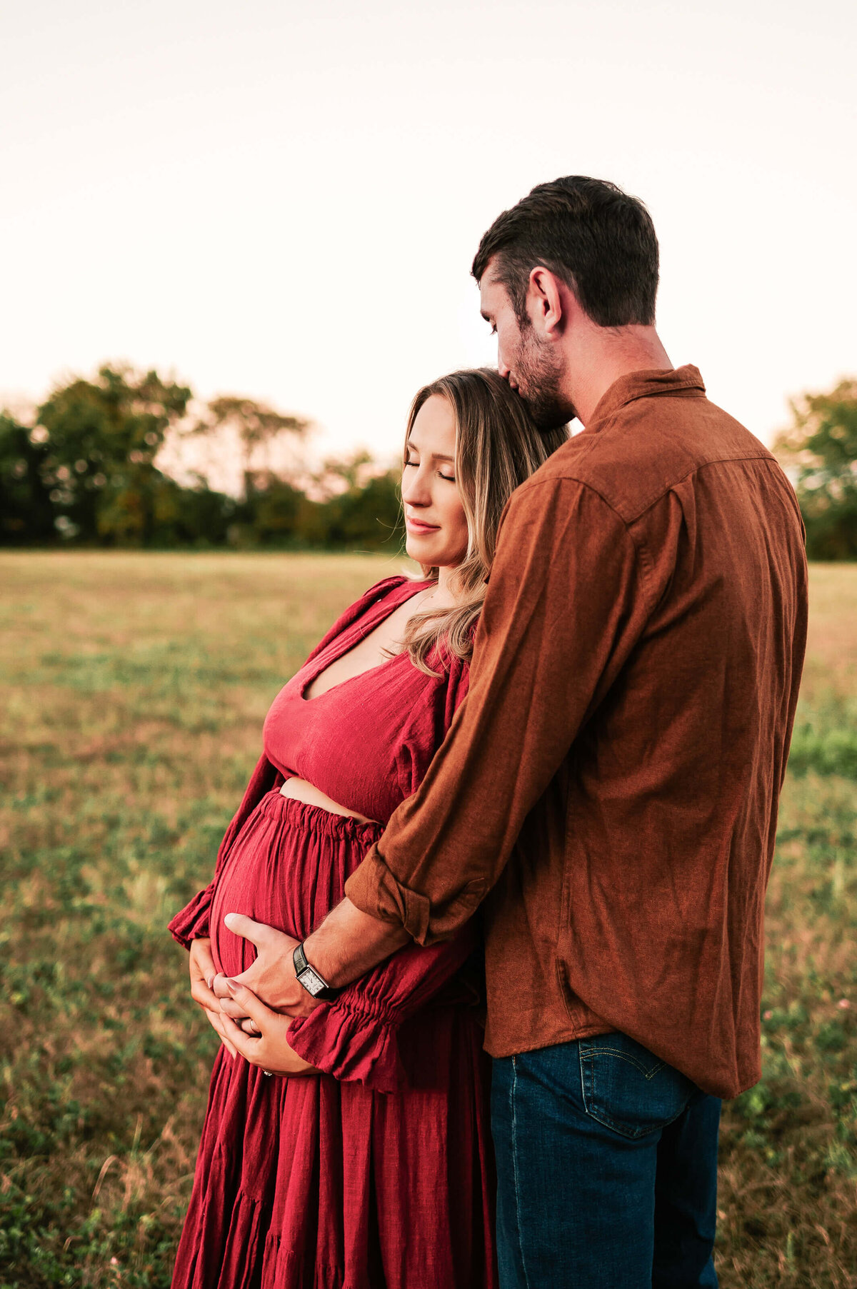 Springfield MO maternity photography of side profile of pregnant mom kissed by her husband