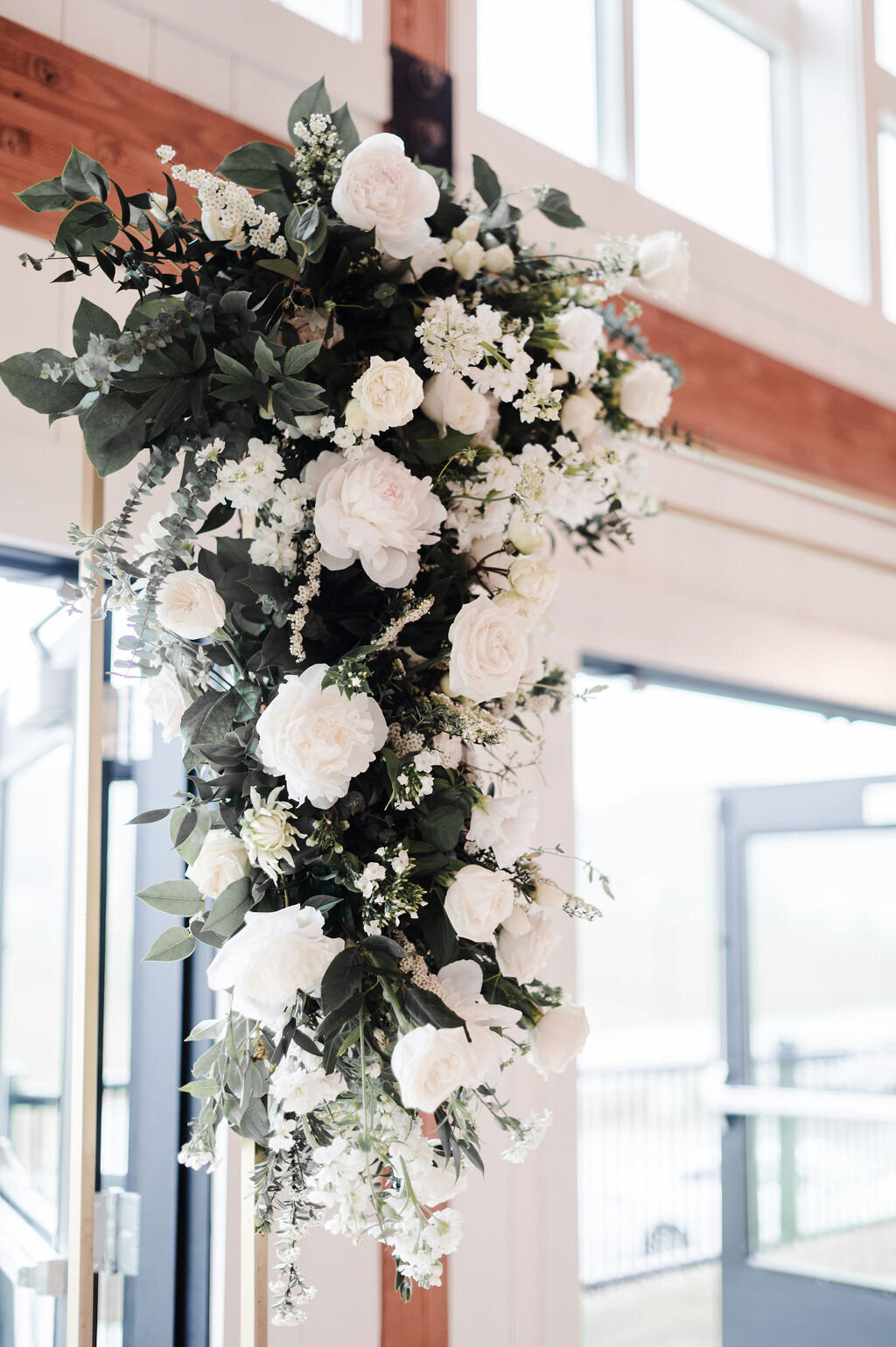 Gold arbor with white florals attached to the left corner of gold arbor