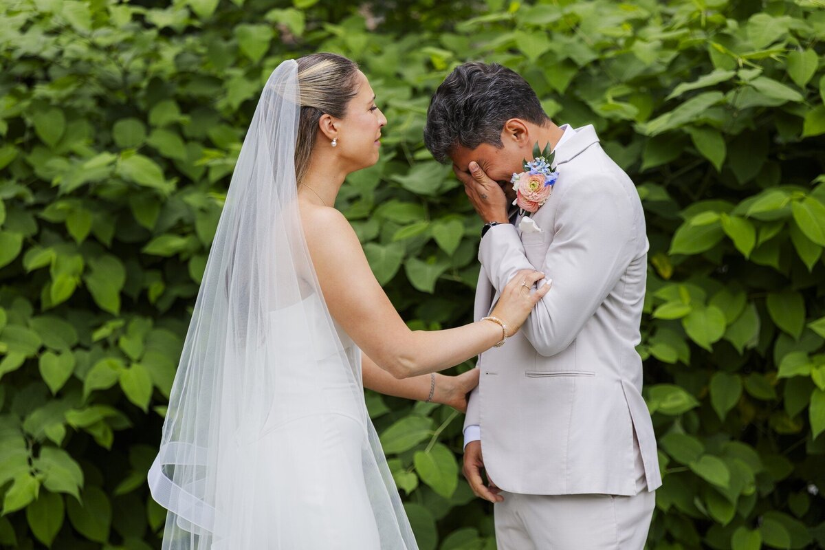 Groom wipes away tears during a first look with his bride at a Roundhouse wedding in Beacon, NY