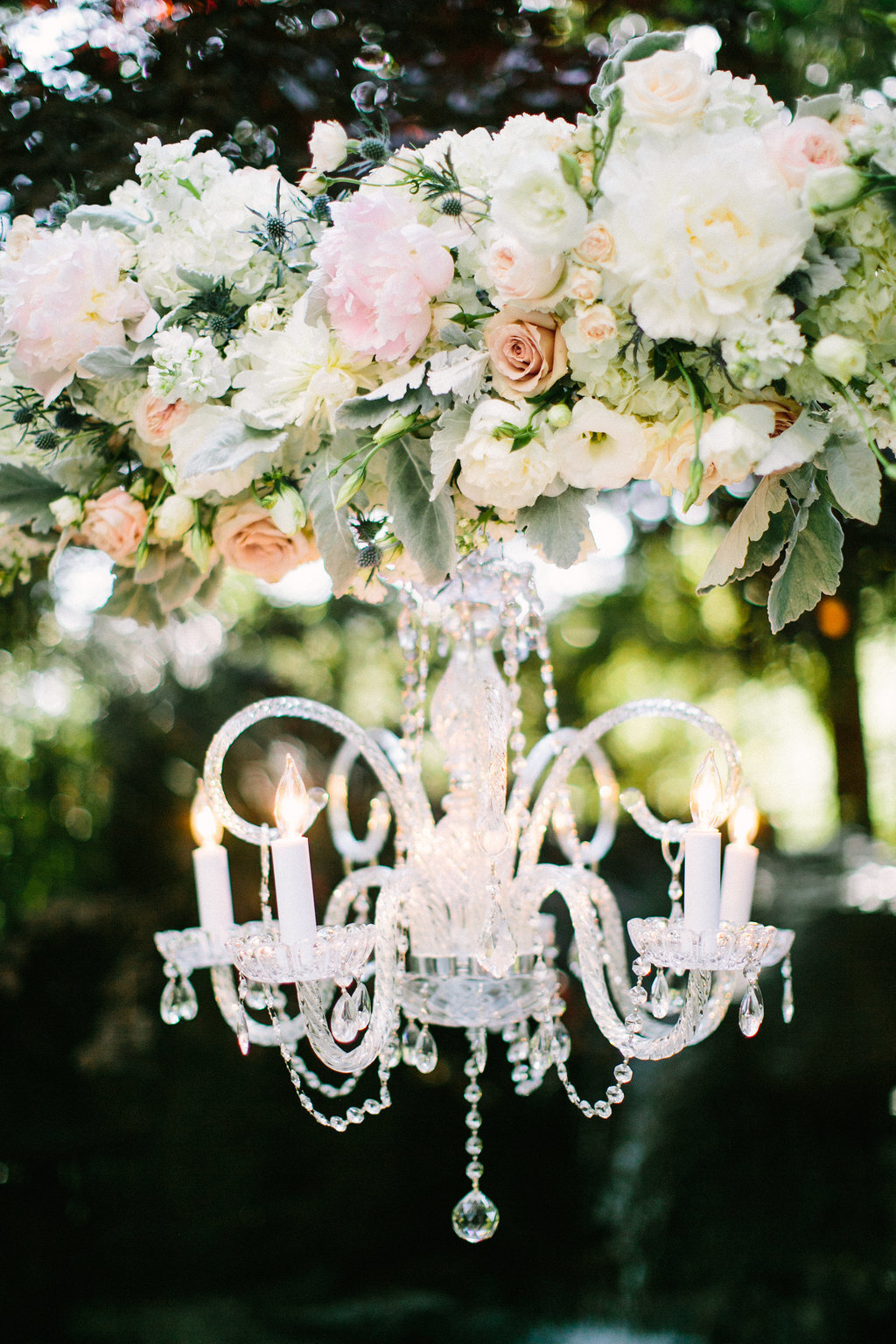 flowers and chandelier hanging from wedding arch