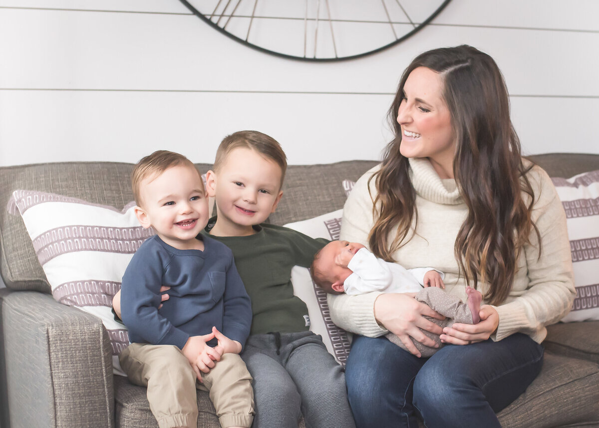 Mom with small sons in their home with their new baby