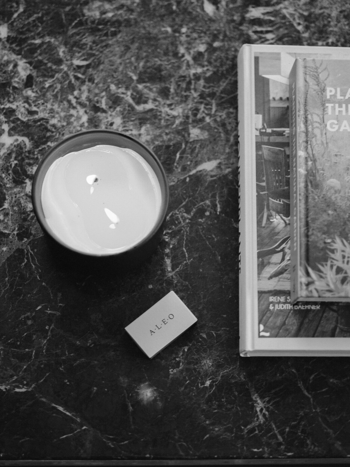 candle, branded ALEO Detroit matches, magazine on marble table, film brand photography in Michigan