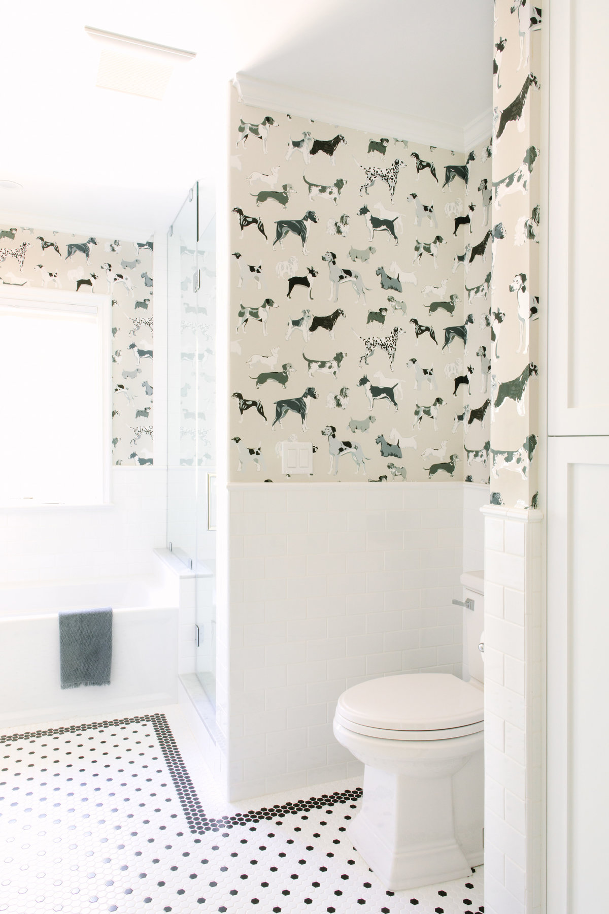 Black and white bathroom with dog wallpaper, subway tile, and black and white hexagon floor tile