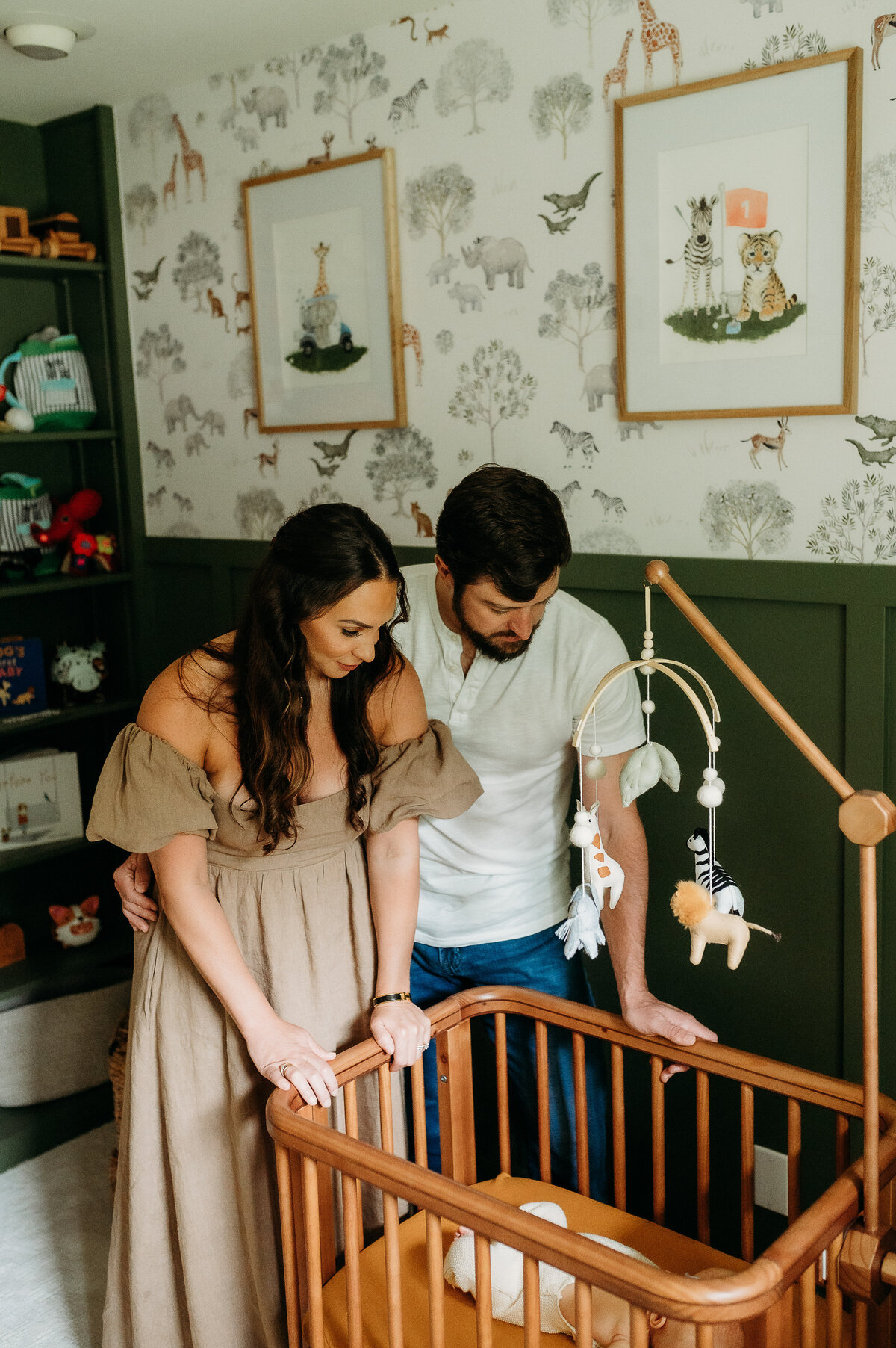 parents gaze at their sweet sleeping baby in his high-end crib.