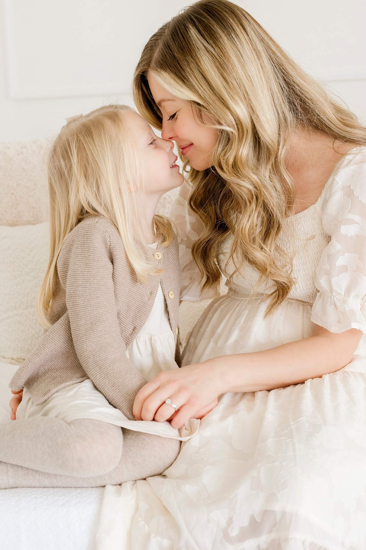 A loving family shares genuine smiles during an elegant, white studio photography session with Alexandra Robyn Photo + Design