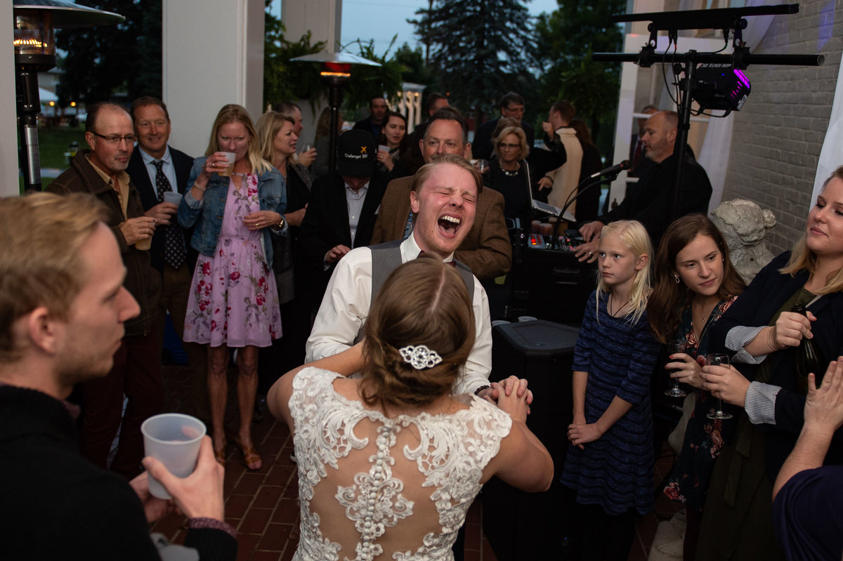 man of honor throws head back in screaming laughter