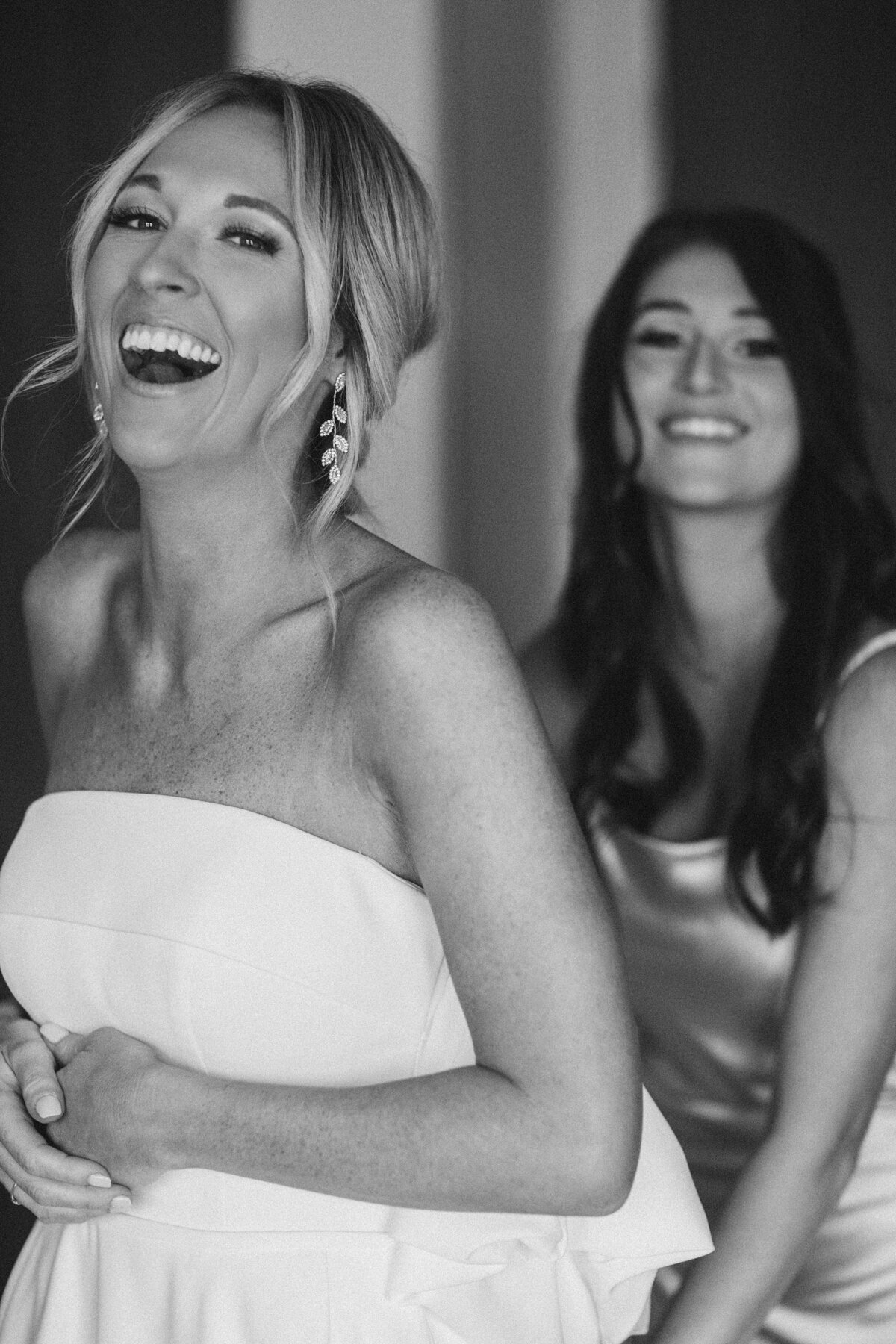 Bridesmaid helps her bride into her wedding gown