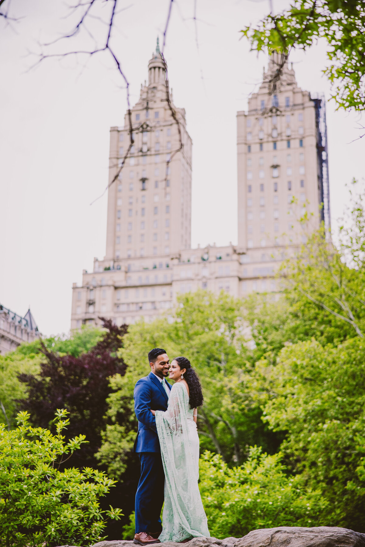 Engagement couple in indian sari share a moment on top of hernshead rock at central park ladies pavilion