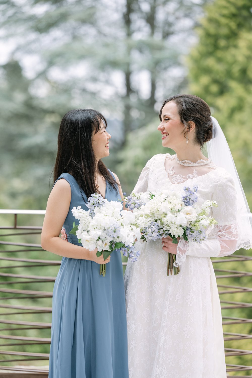 bride and friend laughing during portraits outside at kubota garden