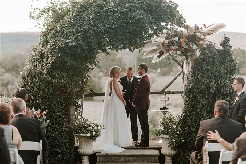 Bride and groom in front of the floral arch