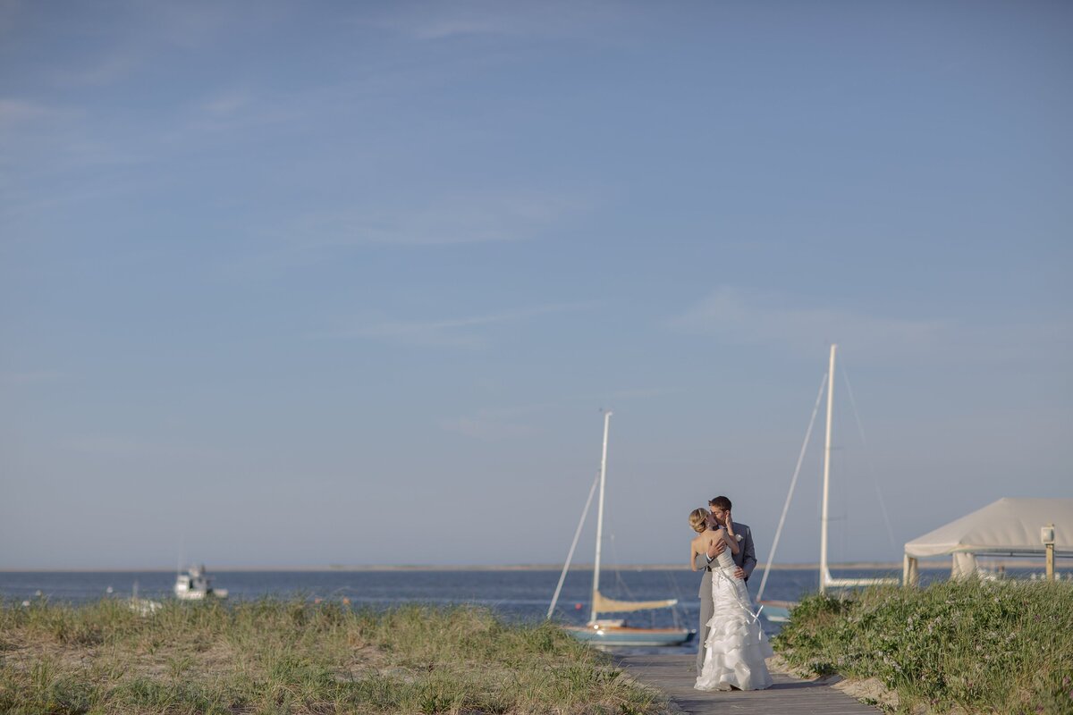 Bride and Groom kiss with Chatham Bars Inn in the background.
