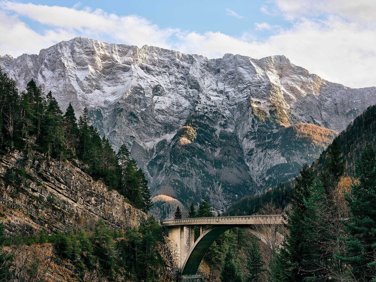 Beeindruckende Bergkulisse mit massiver Steinwand und Brücke in Slowenien – fotografiert vom Fotograf Atelier Schulte. Spezialist für Alpenlandschaften, professionelle Landschaftsfotografie in ganz Österreich und Panoramafotografie mit außergewöhnlichen Lichtstimmungen.