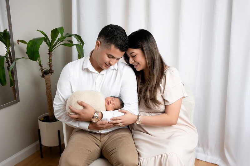 Couple embracing during Houston family photography session in soft studio lighting.