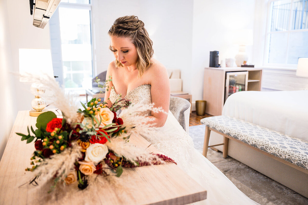 A bride sits at a desk in a hotel room at Fire Station One in Downtown Roanoke to write her vows for her elopement ceremony.