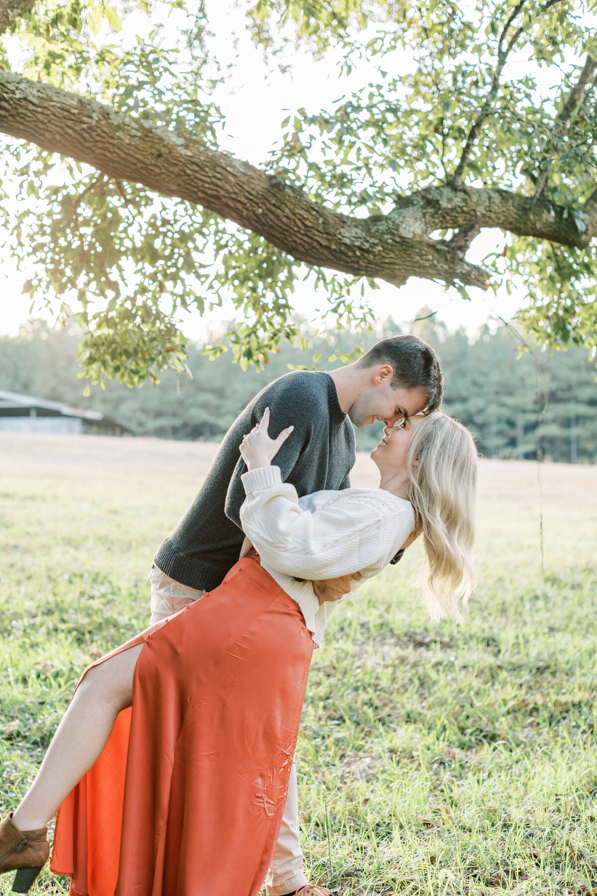 A couple embraces each other in a field.