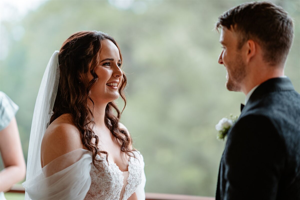 A couple stands lovingly at their ceremony, exchanging vows with heartfelt emotion.