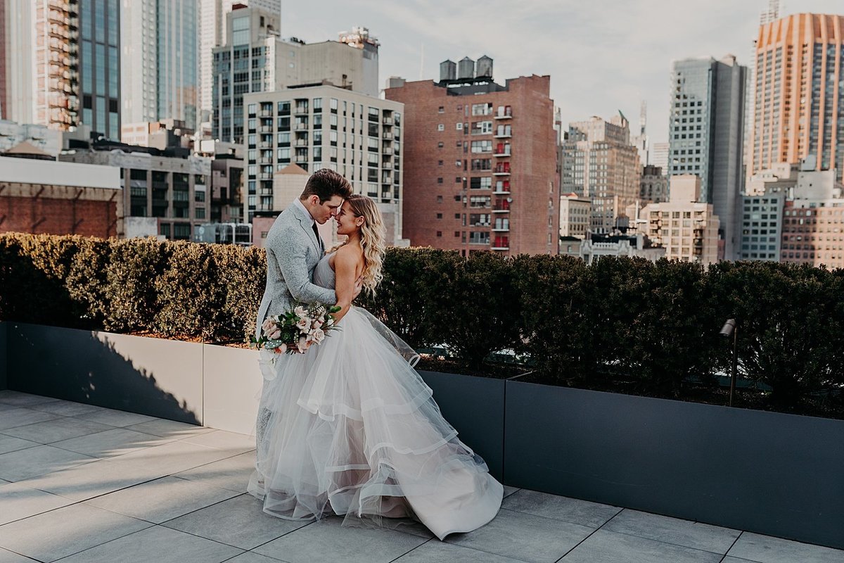 Hayley Paige and Conrad Louis cuddling on a rooftop in New York City