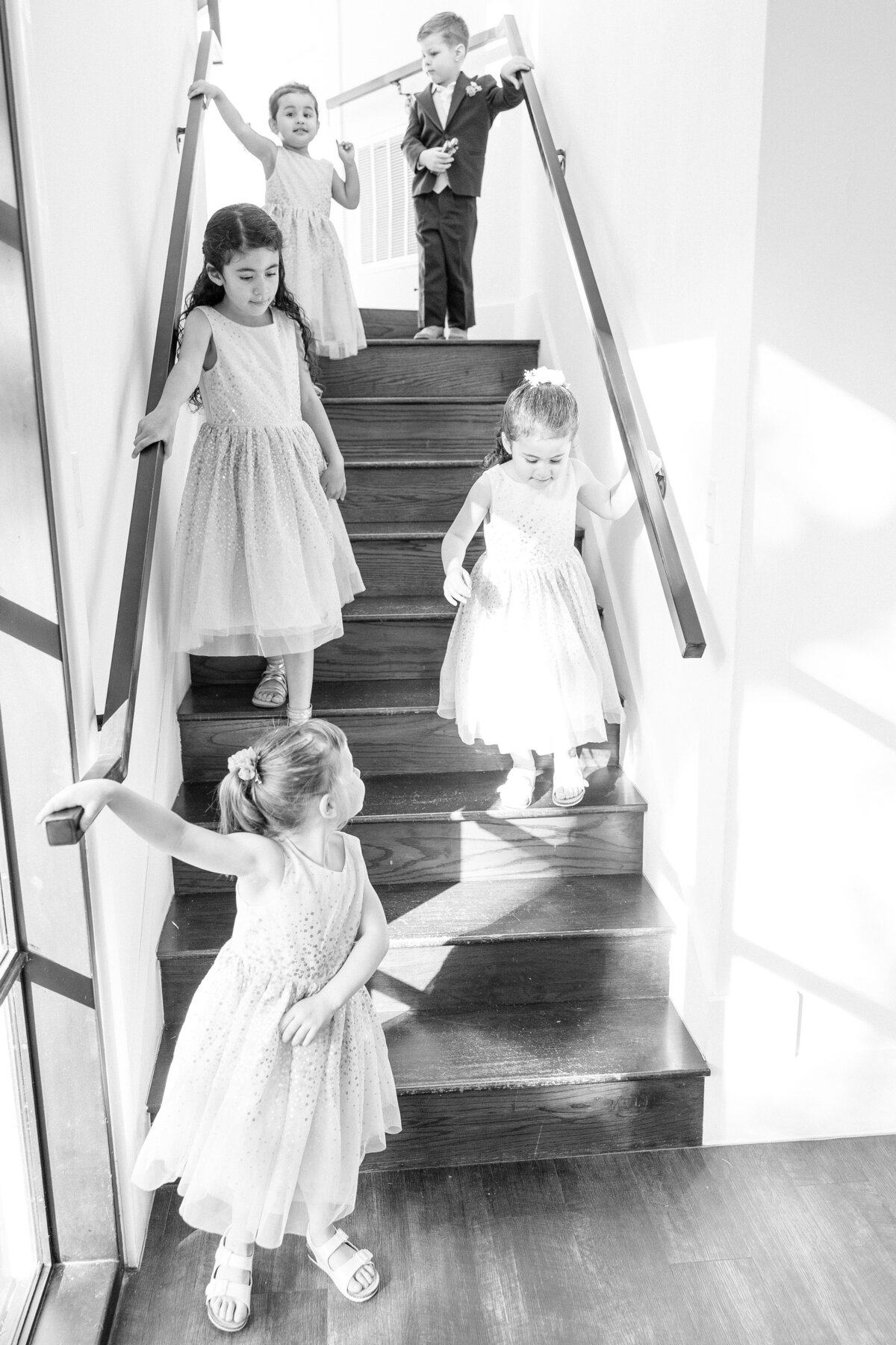 flower girls down stairs in black and white by Texas wedding photographer