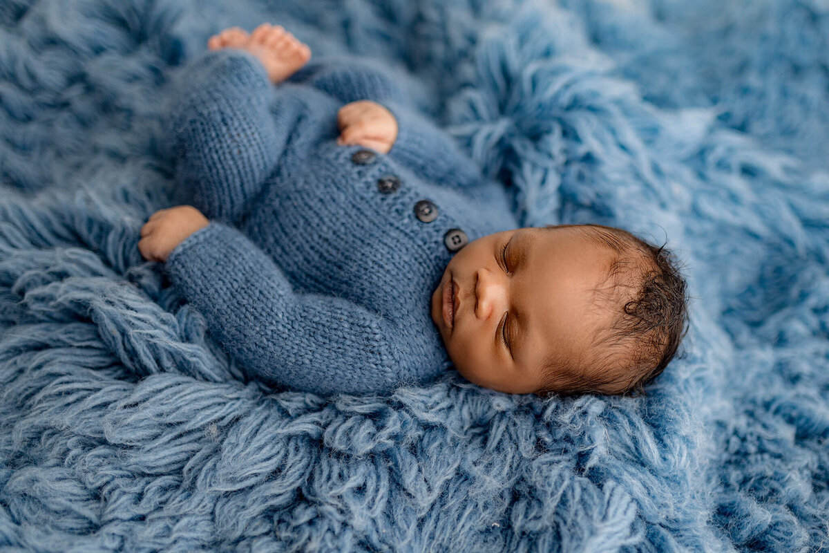 baby boy posed on blue rug asleep