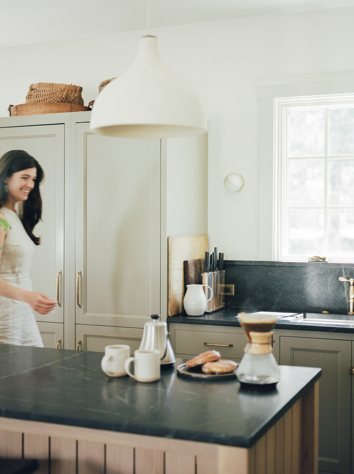 smiling designer in beige linen jumpsuit in kitchen, Fernhaus, Northern Michigan branding photoshoot on film