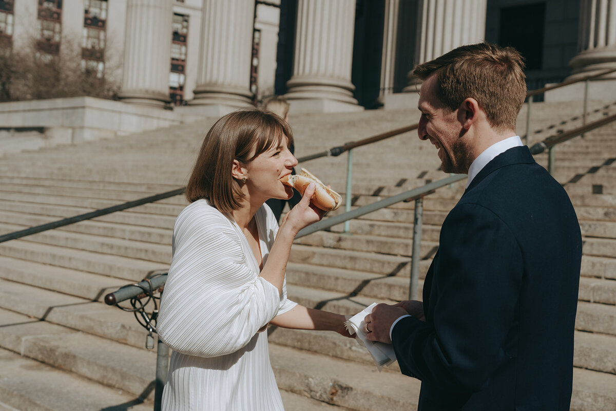 couple eating hot dogs outside after NY City Hall elopement shot by Elsie Goodman Photography | NYC Elopement Packages