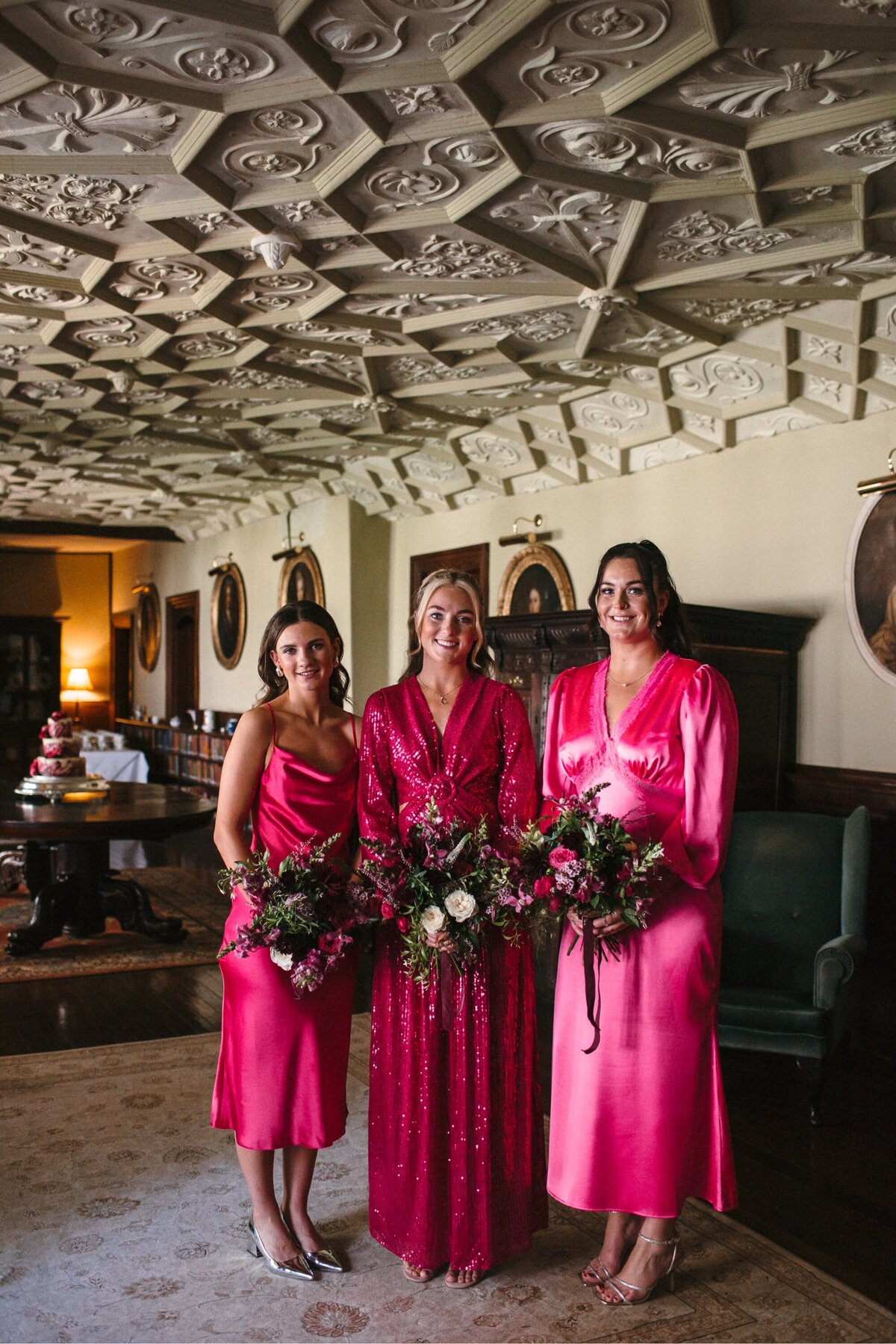 Bridesmaids wearing hot pink mismatched dresses