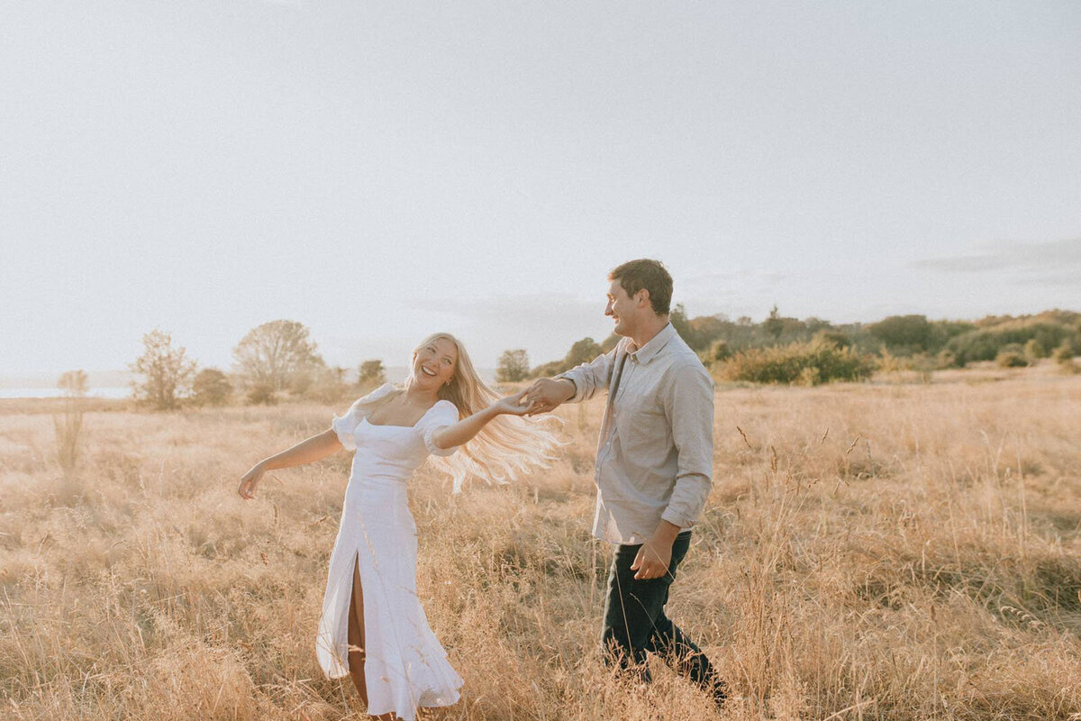 Couple dancing in a field during golden hour