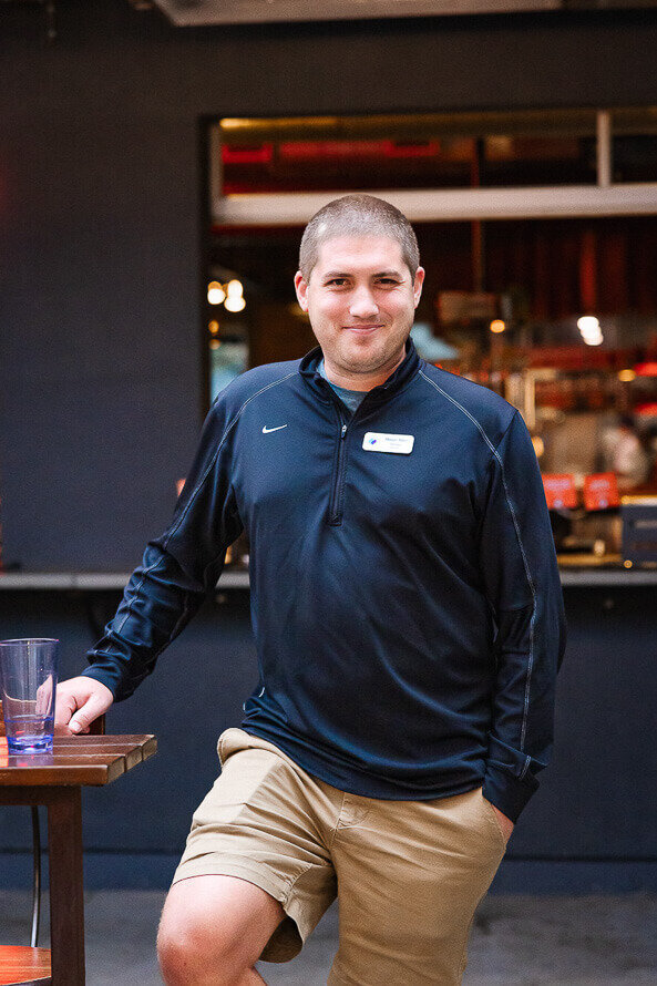 Man smiles for the photographer at his companies event.