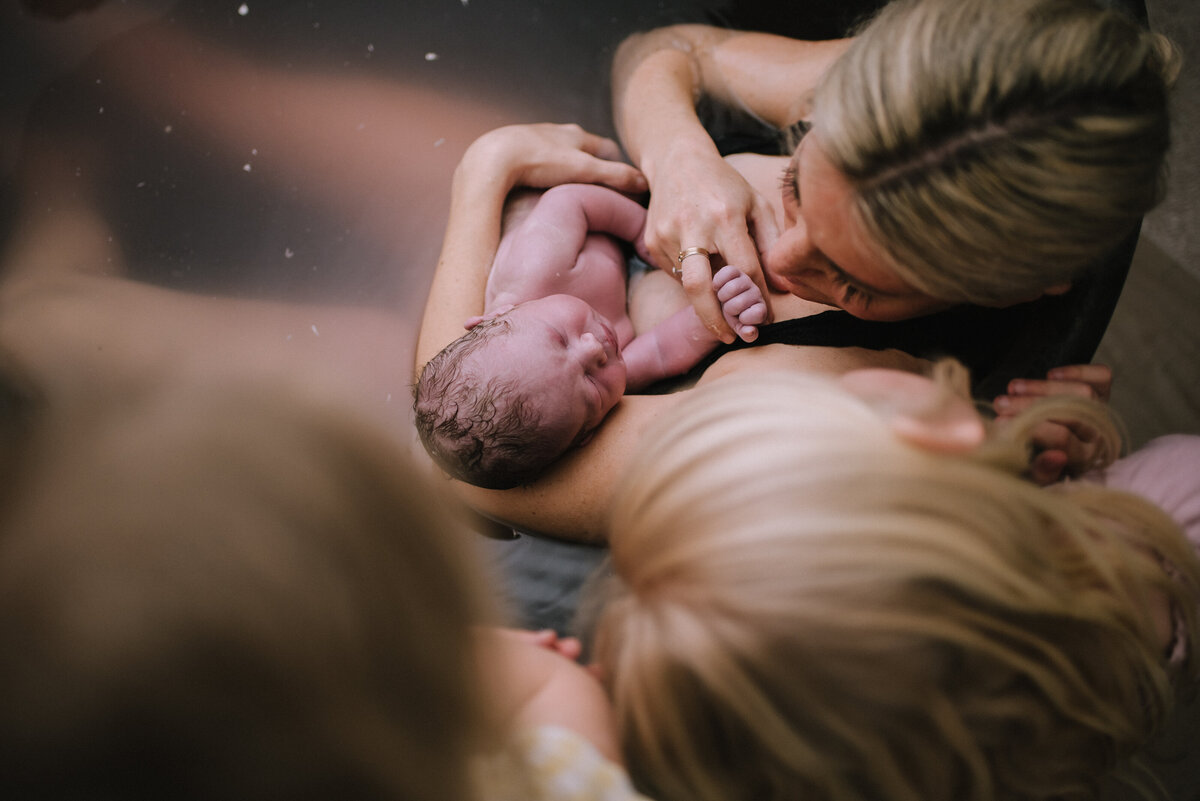A close-up of a newborn’s hand gripping their parent’s finger, representing the delicate beginnings of life and the bond between parent and child.