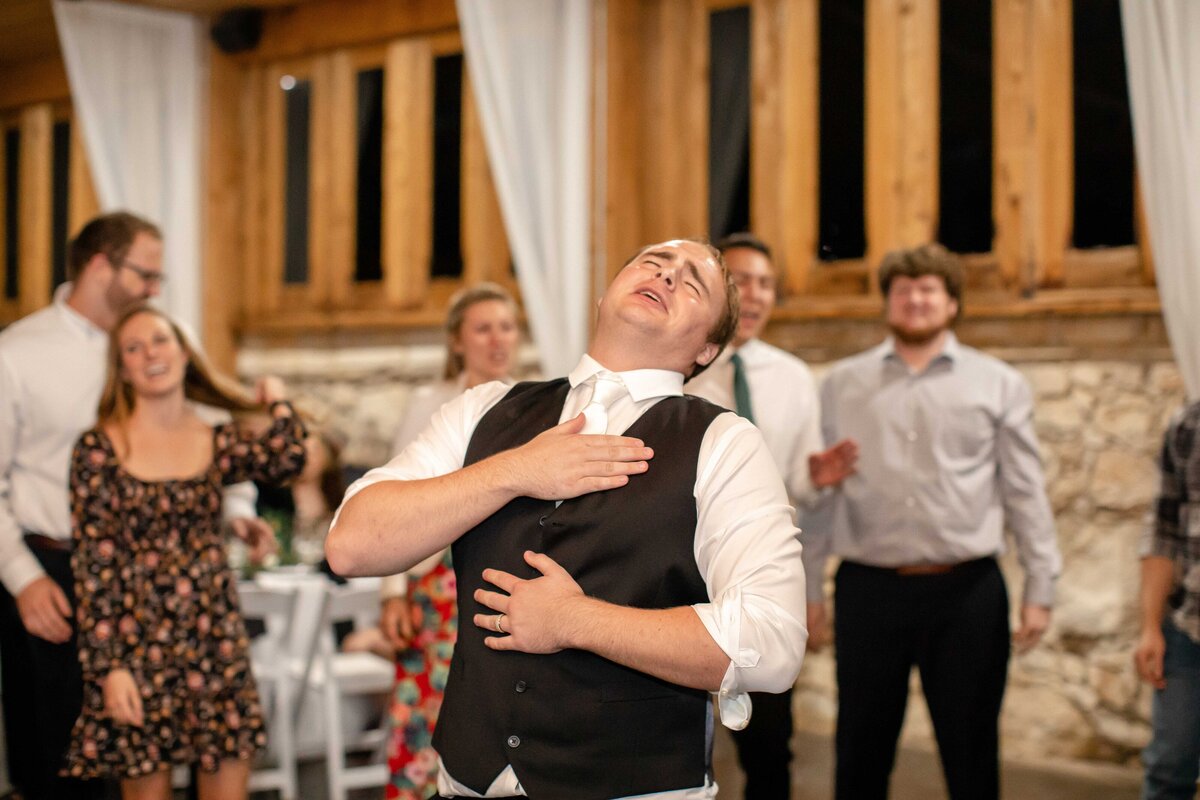 groom in black vest holds chest in reception dance at Milltown Historic District in New Braunfels Texas