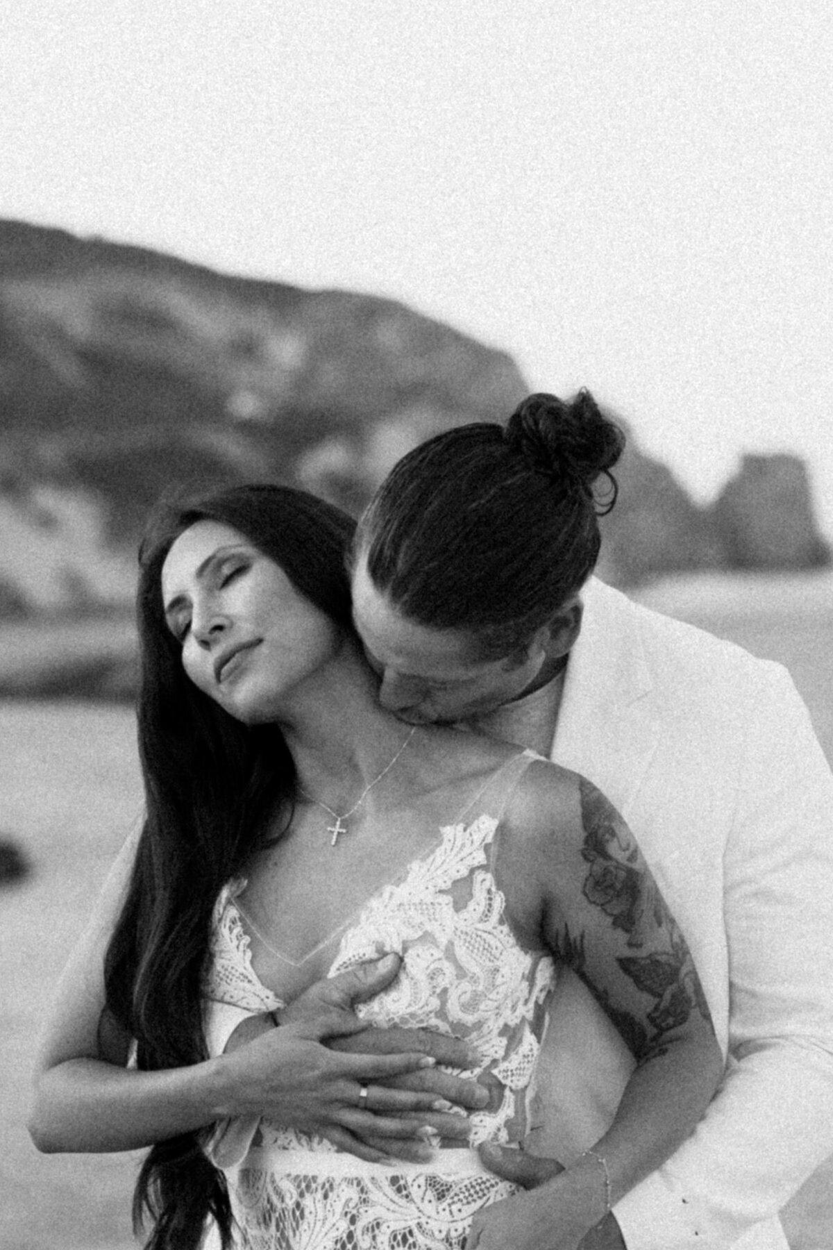 Groom is kissing bride in the neck during a photoshoot after the elopement wedding