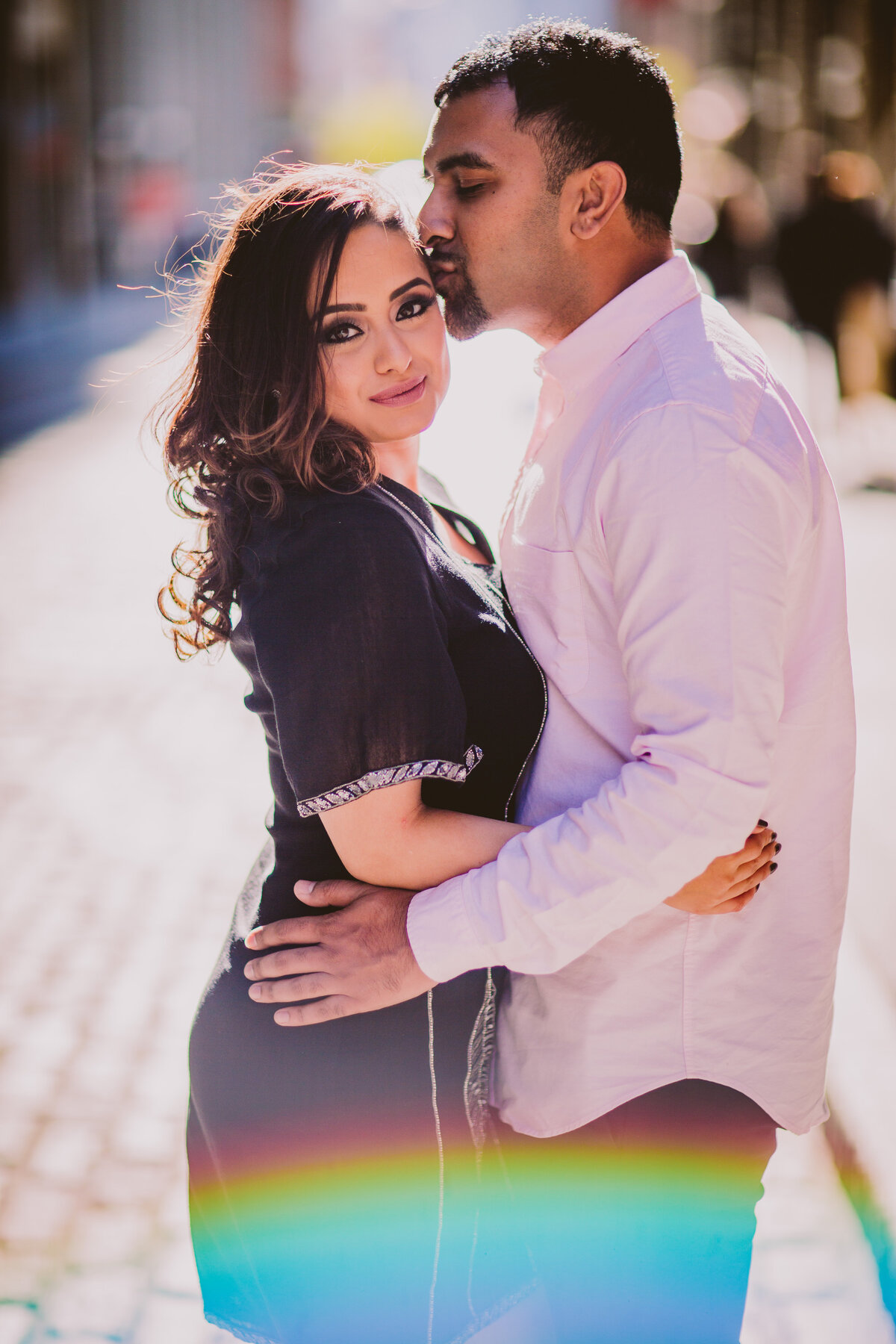 A couple sharing a moment on a cobblestone street in brooklyn dumbo