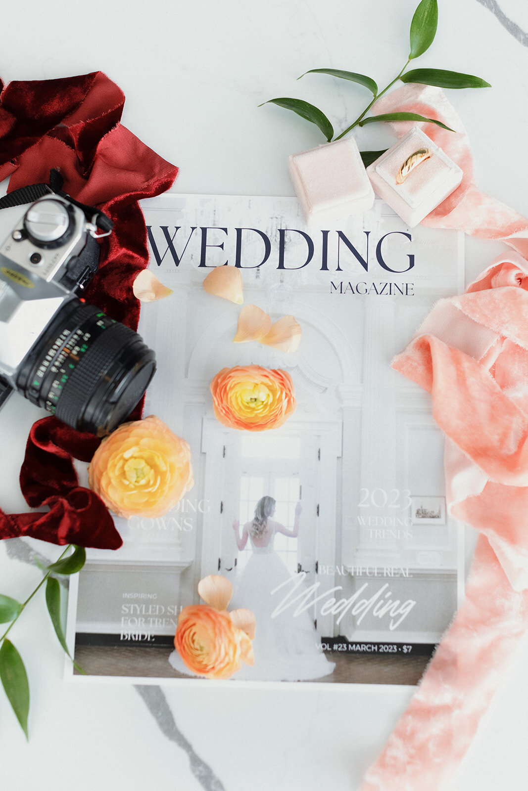 detail photo of wedding magazine, flowers and old camera