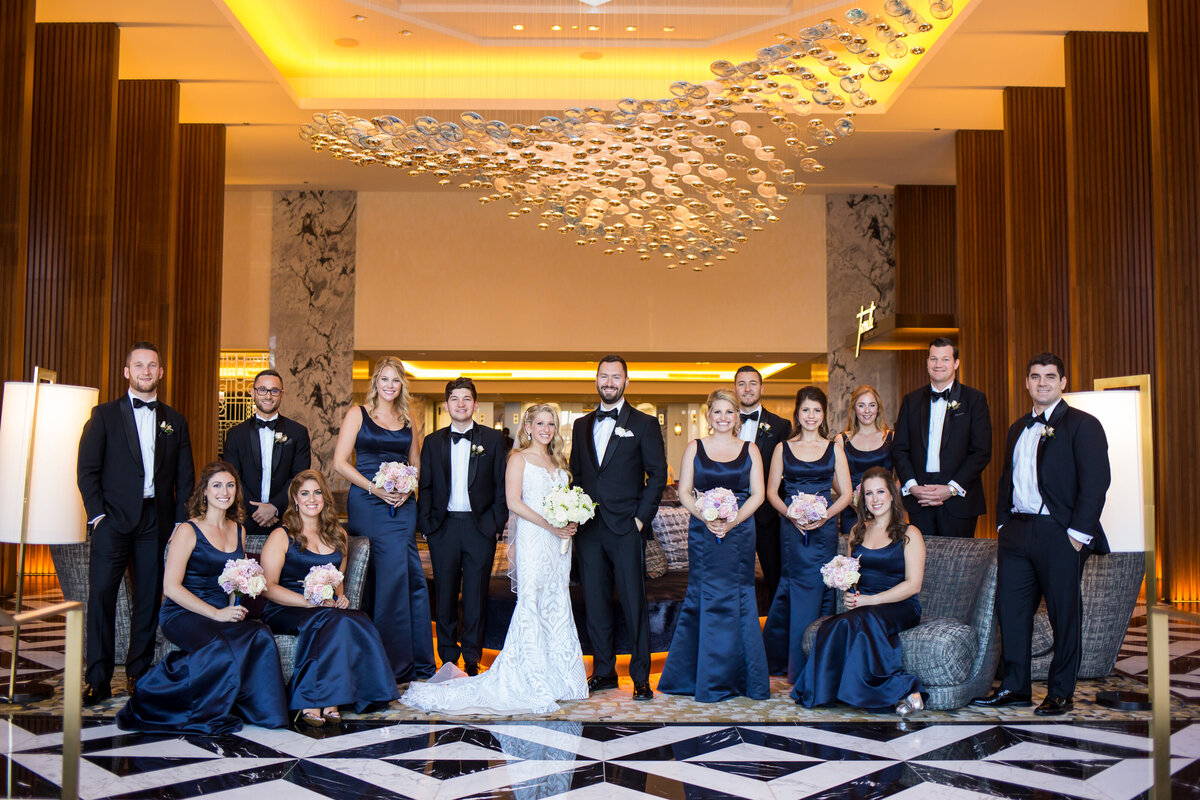 An indoor bridal party photo under a modern chandelier at  Ritz Carlton hotel in Chicago