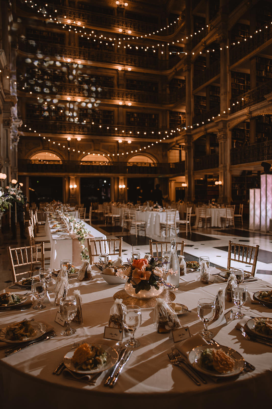 An empty reception hall with intricately set tables 