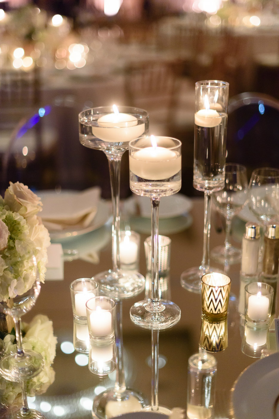 Mirrored table tops reflect the glow of candle light  around the room during this winter wedding.