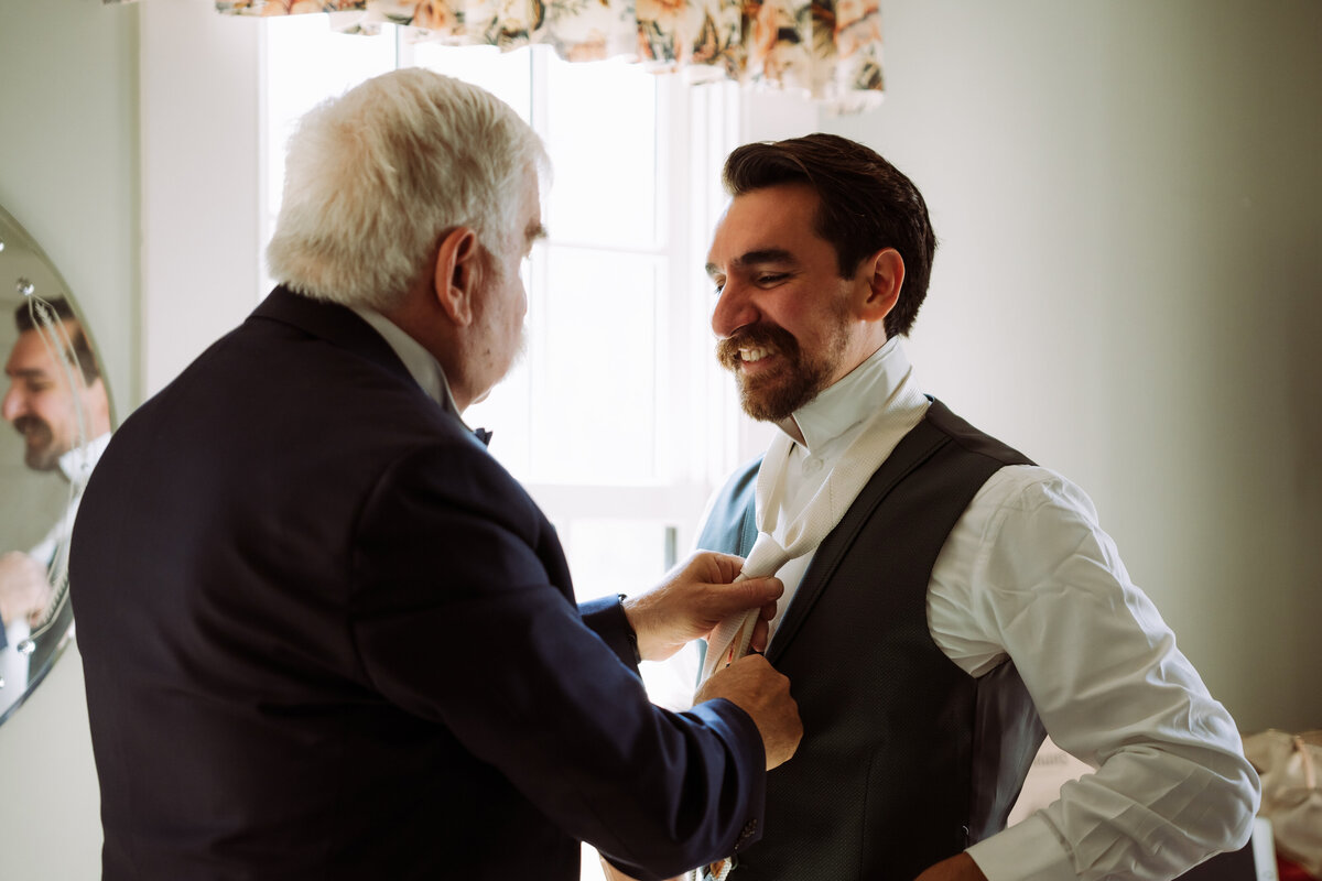 father and groom sharing happy moment