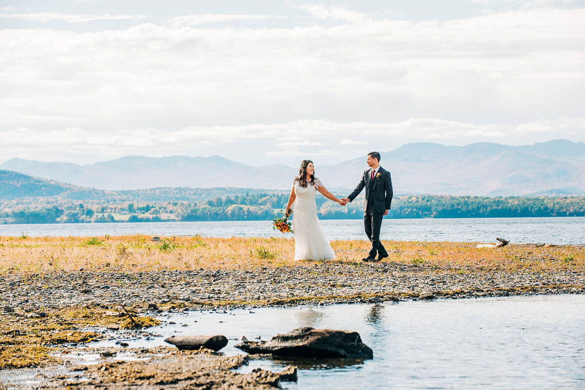 bride and groom walking at lake champlain in charlotte vermont at old lantern inn