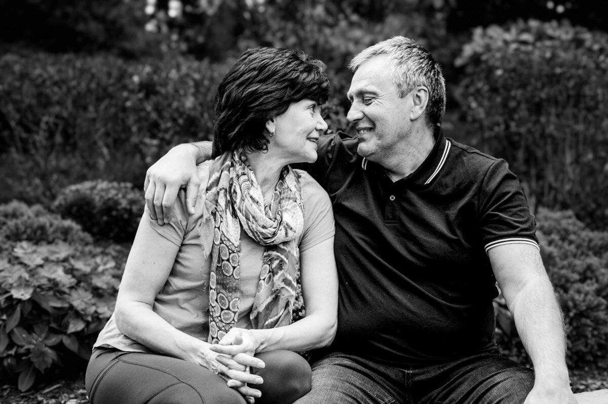 Black and white image of a sweet middle aged couple close together, looking at each other and smiling in South Salem, NY.