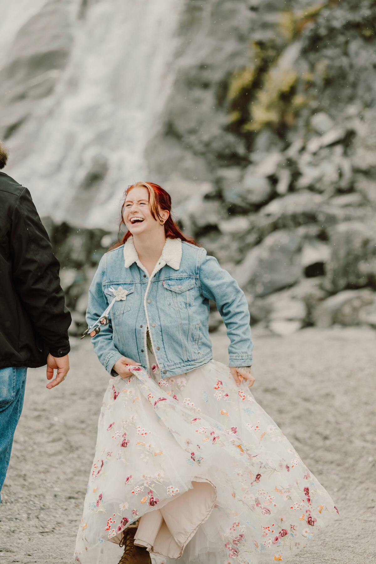 girl laughing and dancing at the waterfall