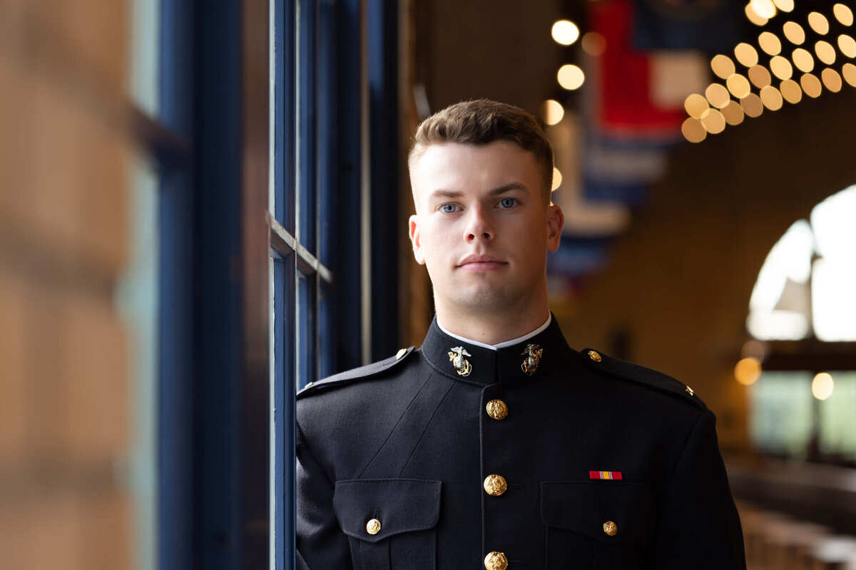 Midshipman Marine poses for a pensive senior photo near the window in Dahlgren Hall at Naval Academy.