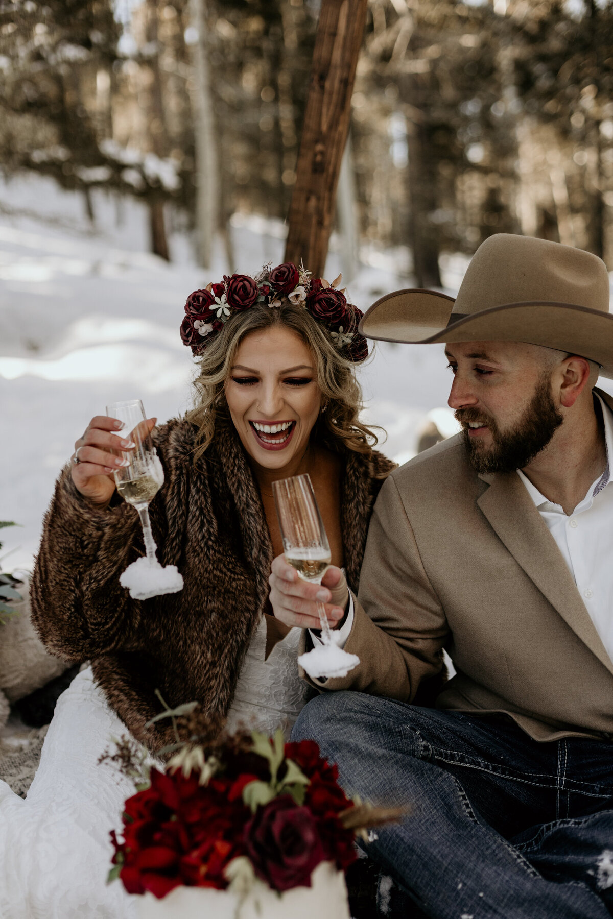 bride and groom drinking champagne in the snow