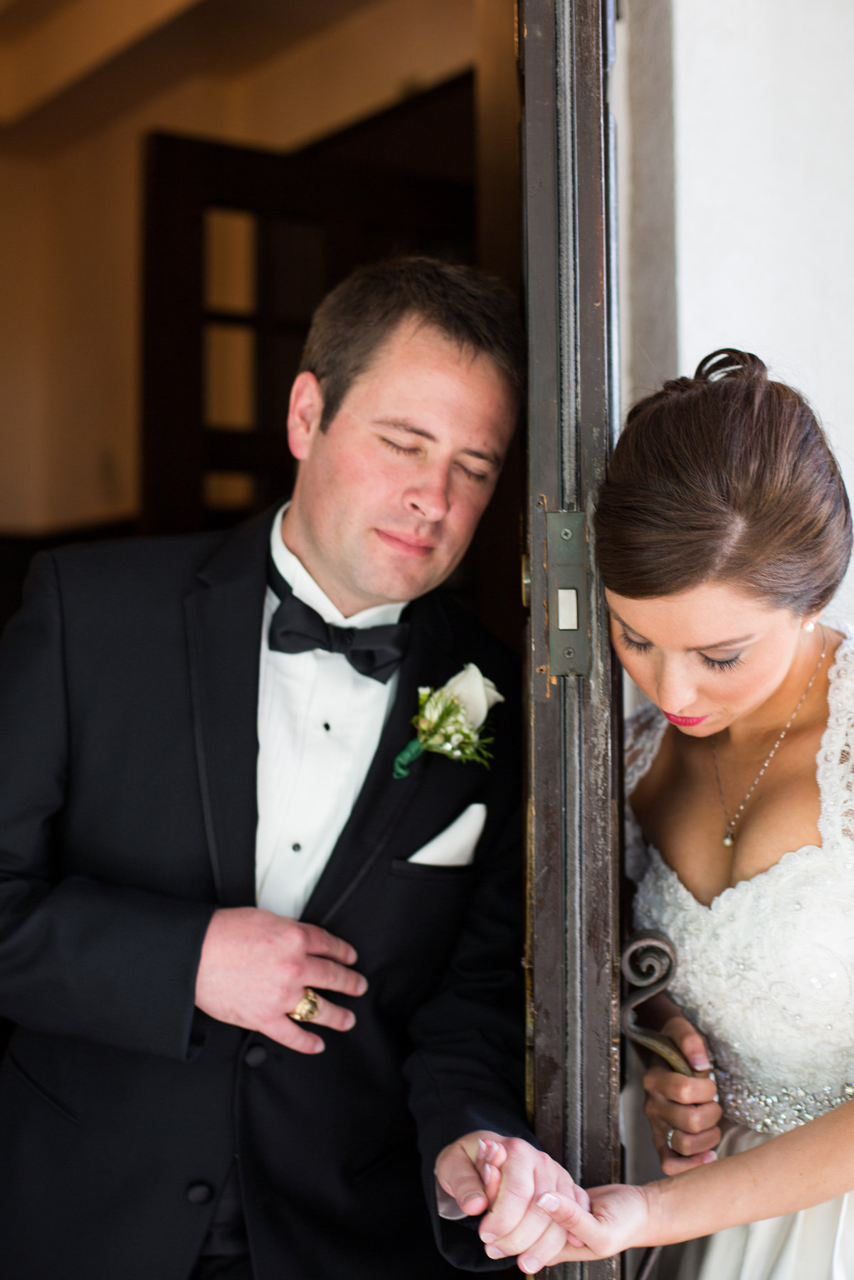 Bride and groom holding hands and saying a prayer for a first touch before their wedding at Alamo Heights United Methodist Church