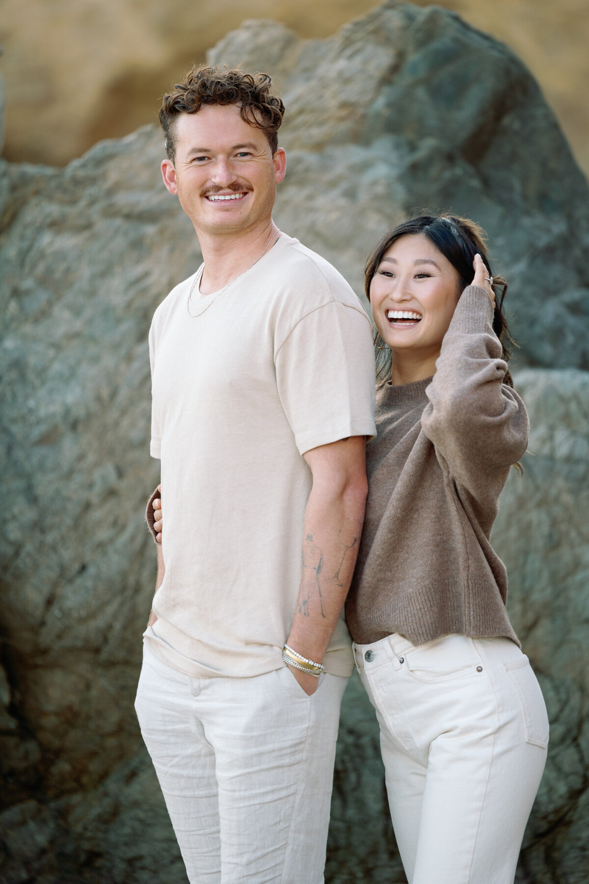 A person laughing with her arm around her partner's back