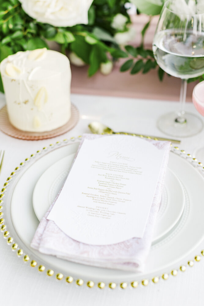 a white menu and napkin sitting on top of a plate