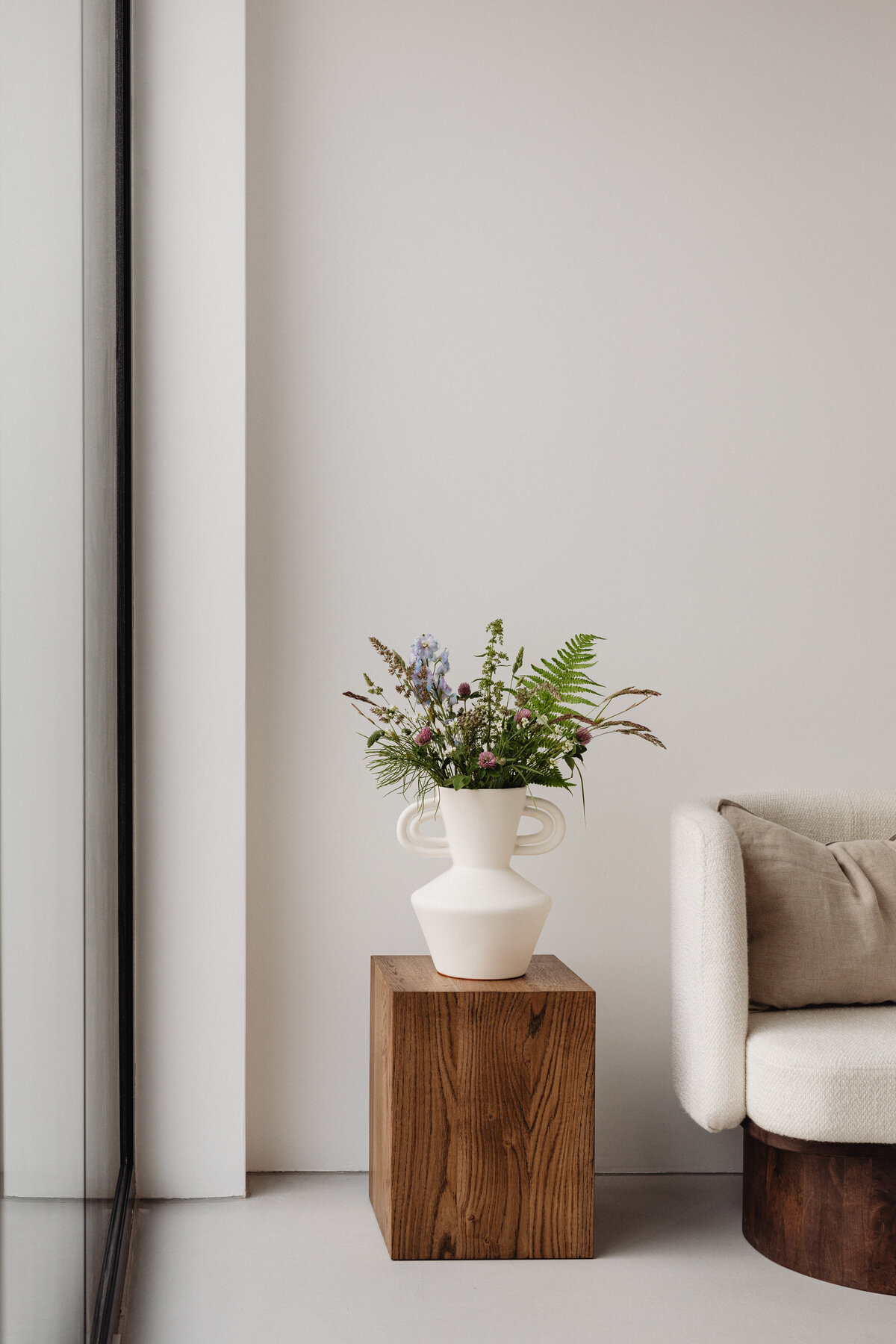 kaboompics_clover-field-flowers-wildflowers-ceramic-vase-side-table-cubicle-walnut-wood-pedestal-upholstered-armchair-26692