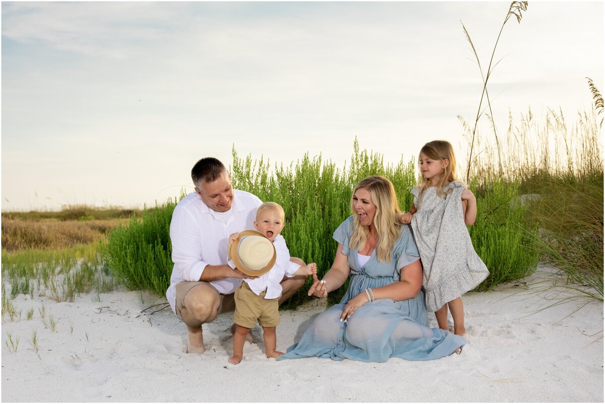 Family of four with young children sitting in the sand at Bean Point on Anna Maria Island